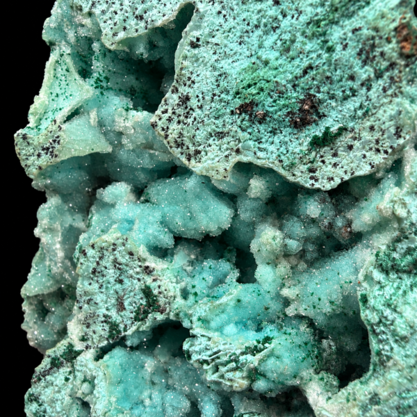 Détail des reliefs turquoise et des motifs sombres de la face principale.